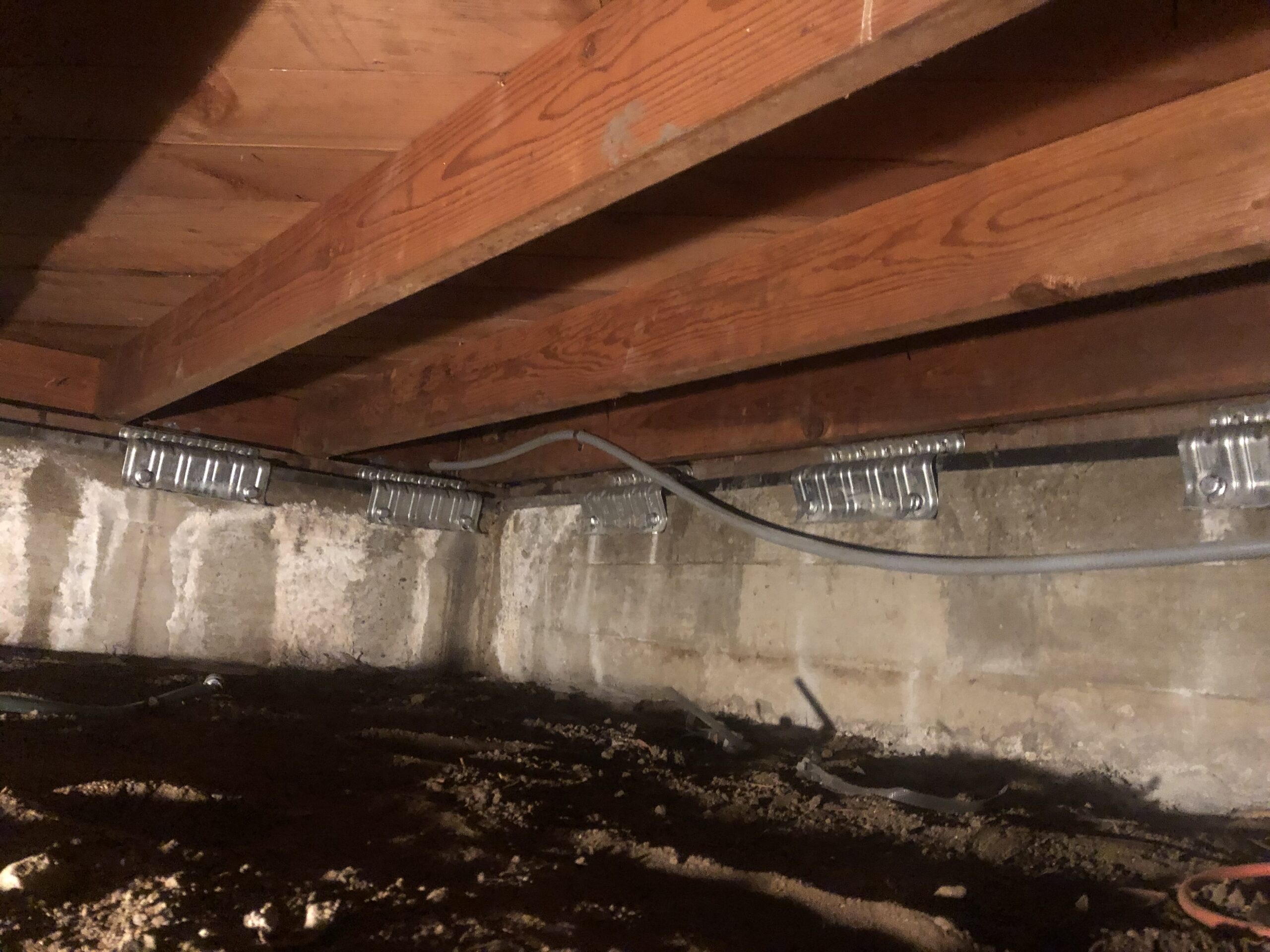 Foundation anchor brackets in crawlspace
